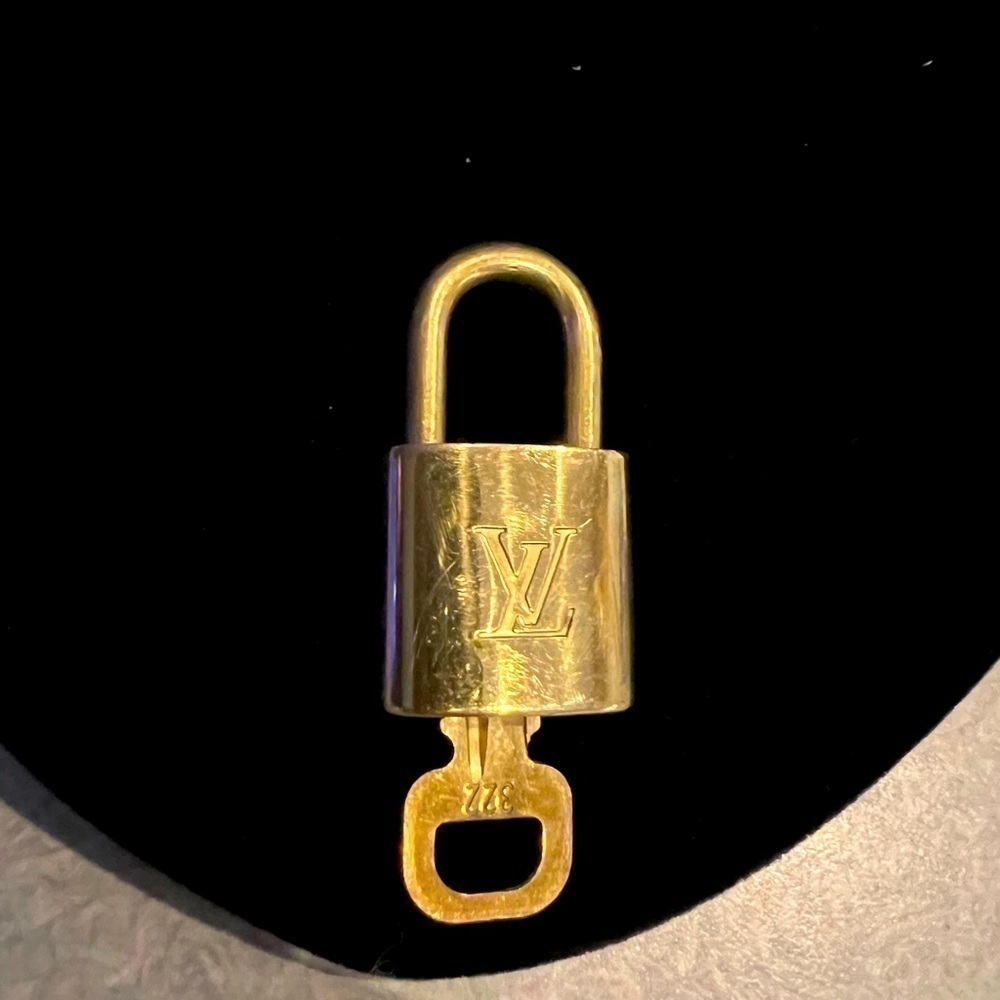 ouis Vuitton lock and key, has wear and is numbered 322.